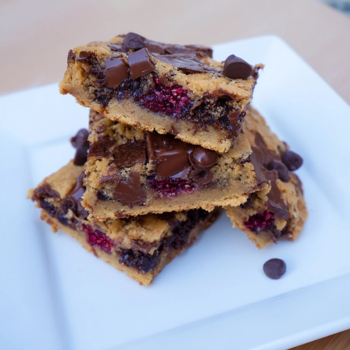 Golden-brown decadent white chocolate and raspberry blondies offer a delicious, sweet dessert experience.