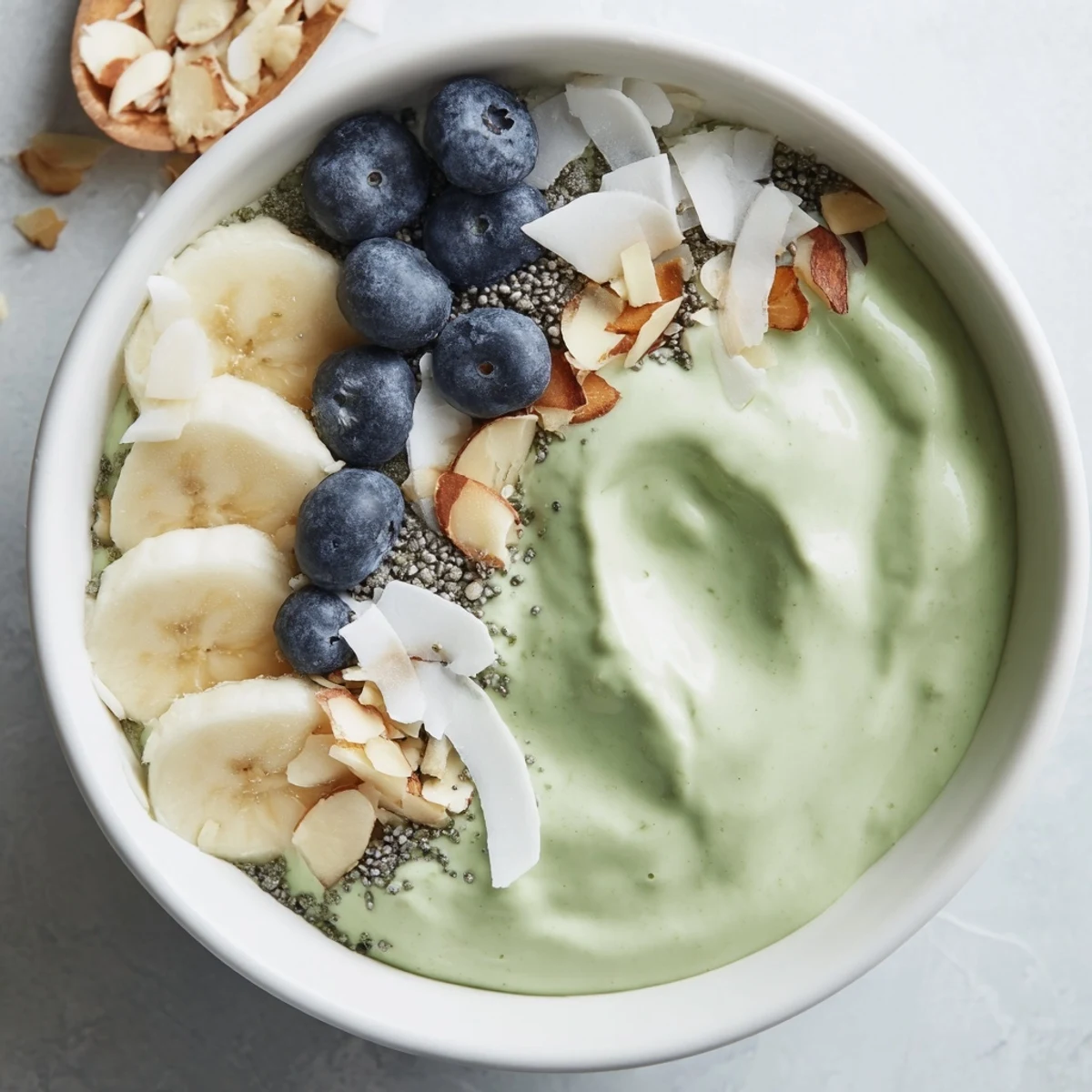 Creamy matcha overnight oats are topped with fresh berries, offering a delightful and healthy breakfast option.