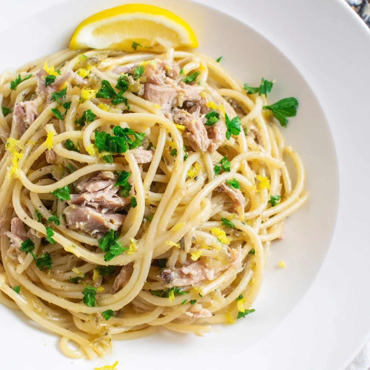 Flaky tuna and zesty lemon-garlic spaghetti tossed with fresh parsley, a quick Italian dinner.