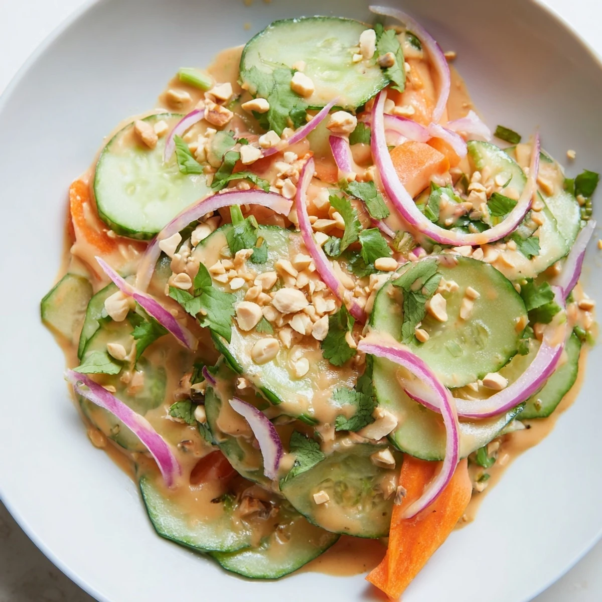 This colorful bowl of Thai-Style Peanut Cucumber Salad features crisp vegetables and roasted peanuts.