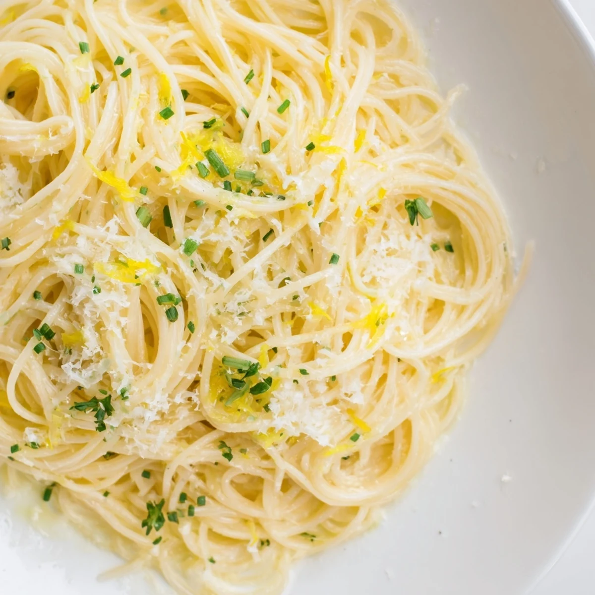 Bright, glistening Lemon Capellini with fresh herbs, ready to be twirled on a fork and enjoyed.