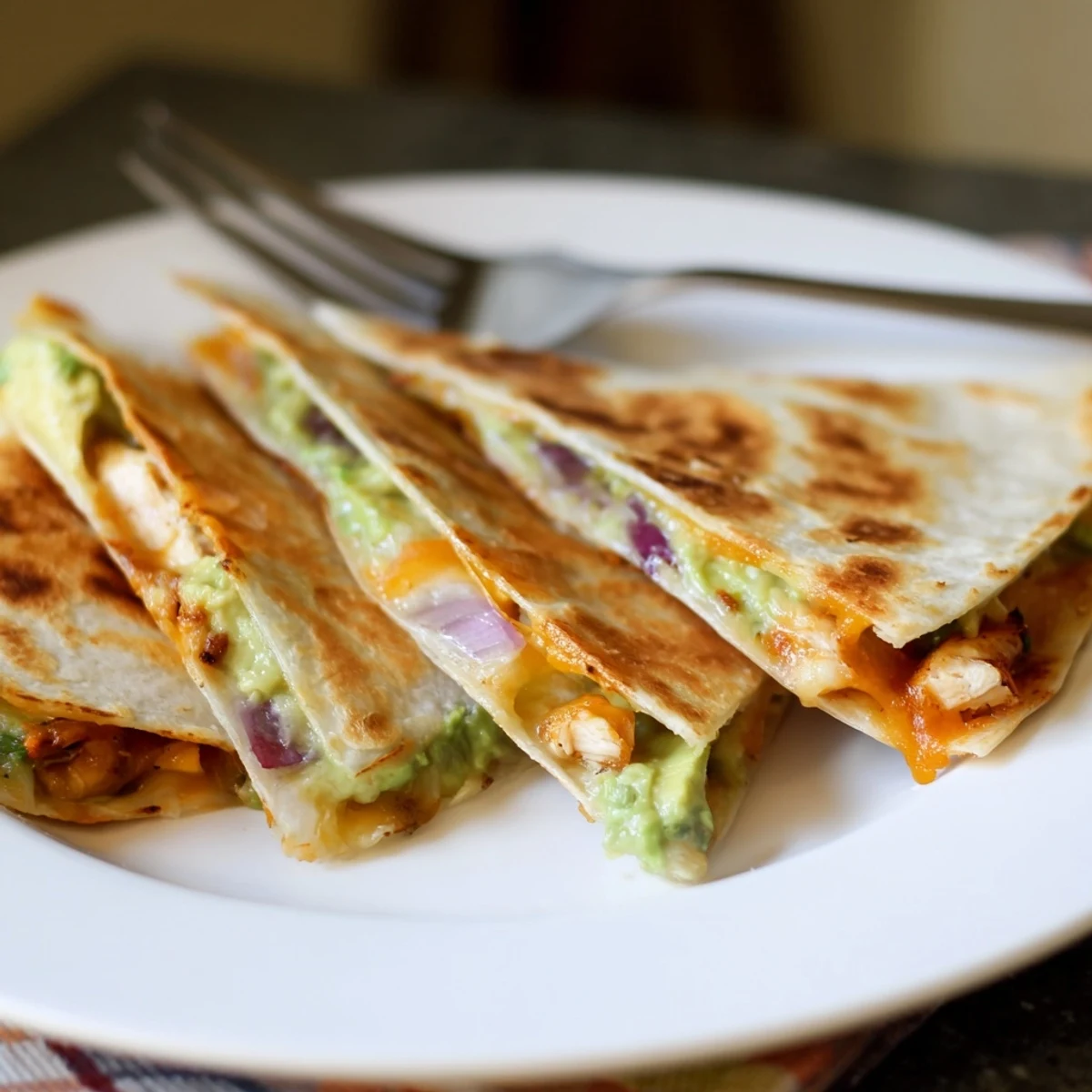 A close-up of a crispy Chicken Avocado Quesadilla filled with juicy grilled chicken and creamy avocado mash.