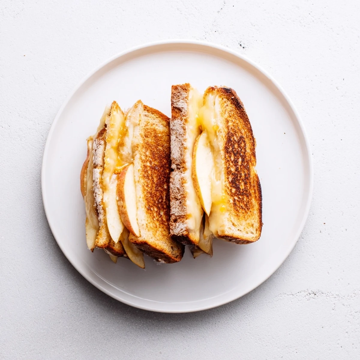 Golden-brown sourdough grilled cheese sandwiches stuffed with melted smoked Gouda and crisp apple slices.