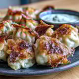 Smash Dumplings arranged on a bamboo serving tray with a small dipping sauce bowl, showcasing their crispy texture and savory, Asian-fusion appeal.