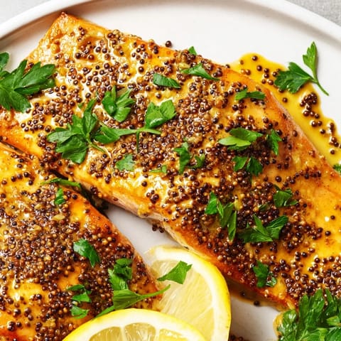 A close-up of honey mustard salmon revealing glistening, tender fillets from the oven, ready to eat.
