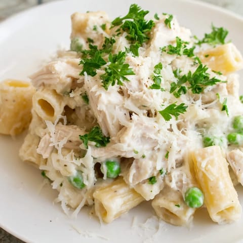 Warm, comforting Slow Cooker Chicken Alfredo Pasta Bake features penne pasta, shredded chicken, and a cheesy Alfredo.