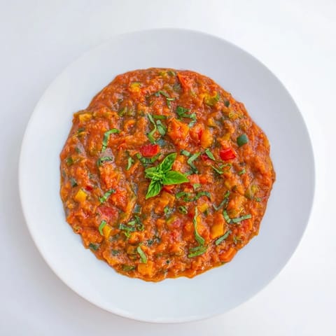 A steaming bowl of Veggie-Loaded Tomato Pasta Sauce with fresh basil garnish, ready for dinner.