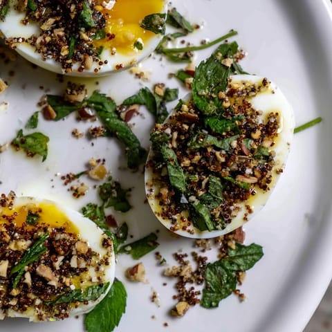 A vibrant close-up displays sliced Dukkah-Spiced Eggs, generously dusted with the aromatic Egyptian spice blend.