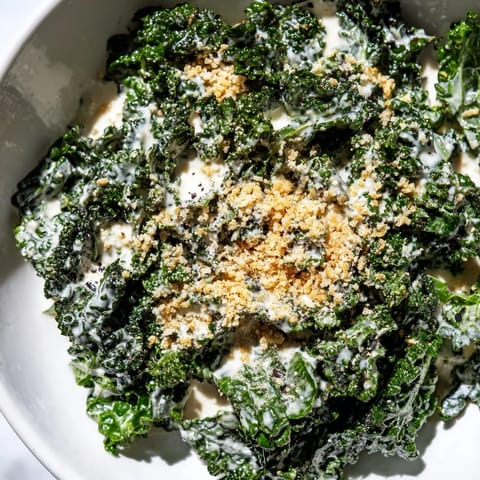 A vibrant Garlic Parmesan Kale Salad with shaved Parmesan, fresh lemon, and crunchy panko topping.  