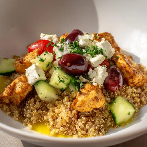 A close-up of the colorful Mediterranean Chicken Bowl, highlighting juicy chicken and tangy feta on a bed of quinoa and fresh vegetables.