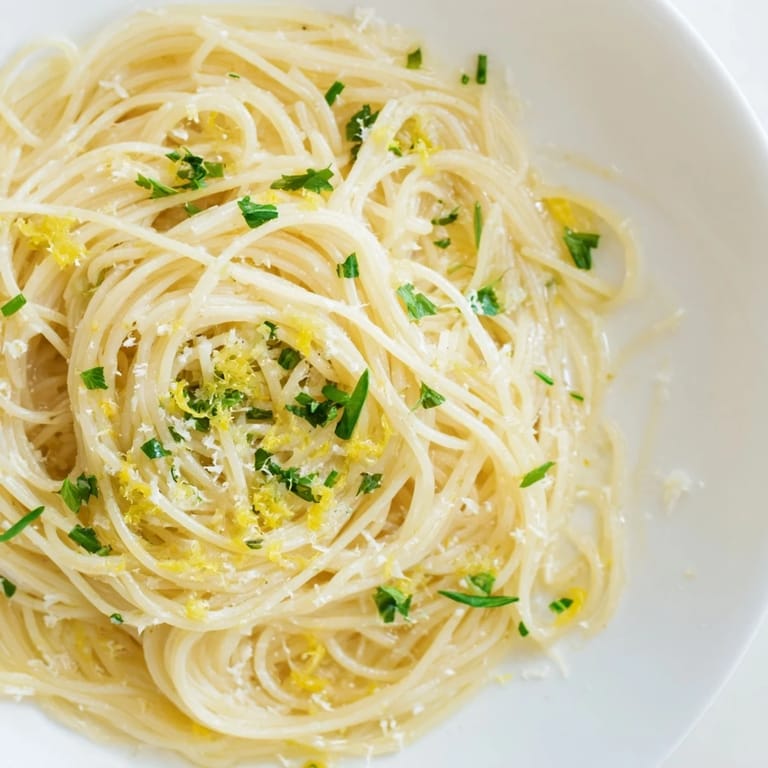 Delicate capellini pasta coated in lemon butter sauce, a flavorful and easy recipe.
