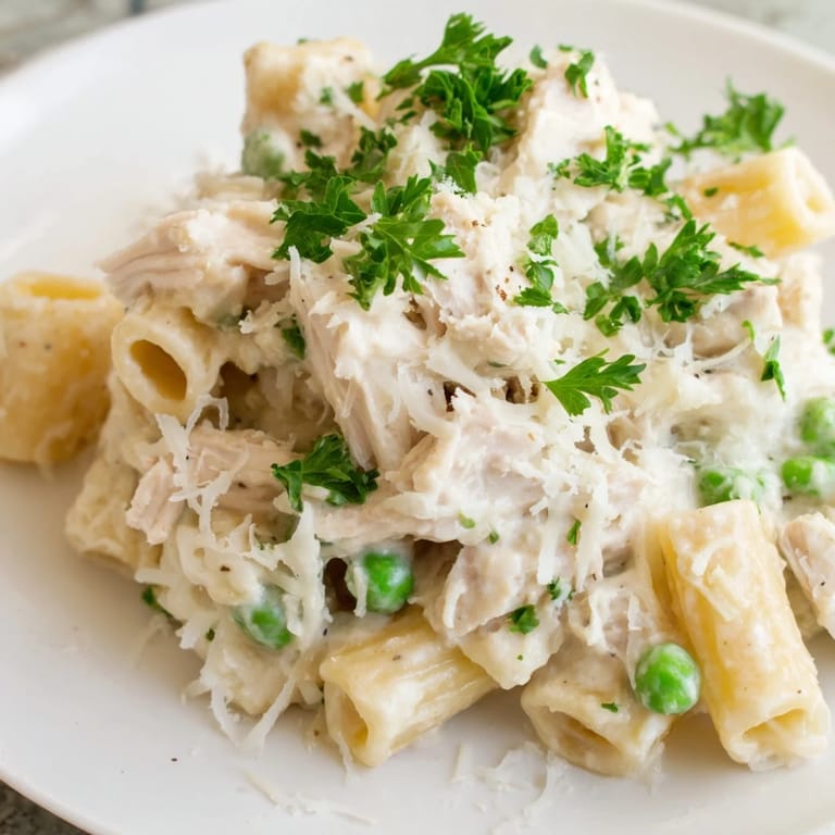 Warm, comforting Slow Cooker Chicken Alfredo Pasta Bake features penne pasta, shredded chicken, and a cheesy Alfredo.