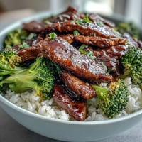 Fluffy rice topped with tender beef strips and crisp green broccoli, all coated in a glossy ginger-soy sauce.