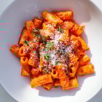Steaming bowl of Microwave Bowl Pasta, ready to eat with a vibrant sauce and fresh herbs.